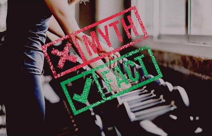 Žena v posilňovni držiaca činky, s nápismi 'Myth' v červenej a 'Fact' v zelenej farbe, ktoré znázorňujú rozdiel medzi mýtmi a faktami o cvičení.